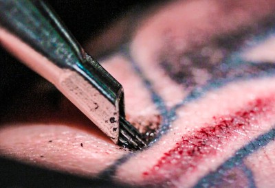 tatuaje inyectando la tinta sangre agujas